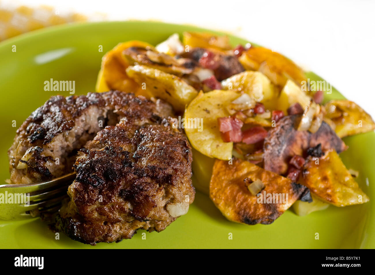 Burger auf einem grünen Teller mit Pommes frites Stockfoto