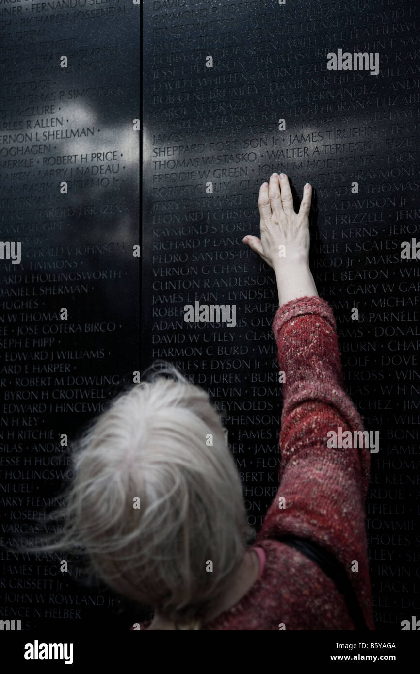 Frau, die Namen von einem Gedenkzustand toten Soldaten an der Vietnam-Veteran Memorial Wand zu berühren. Reflektierte Sturm fügt stimmungsvolle Ambiente Stockfoto