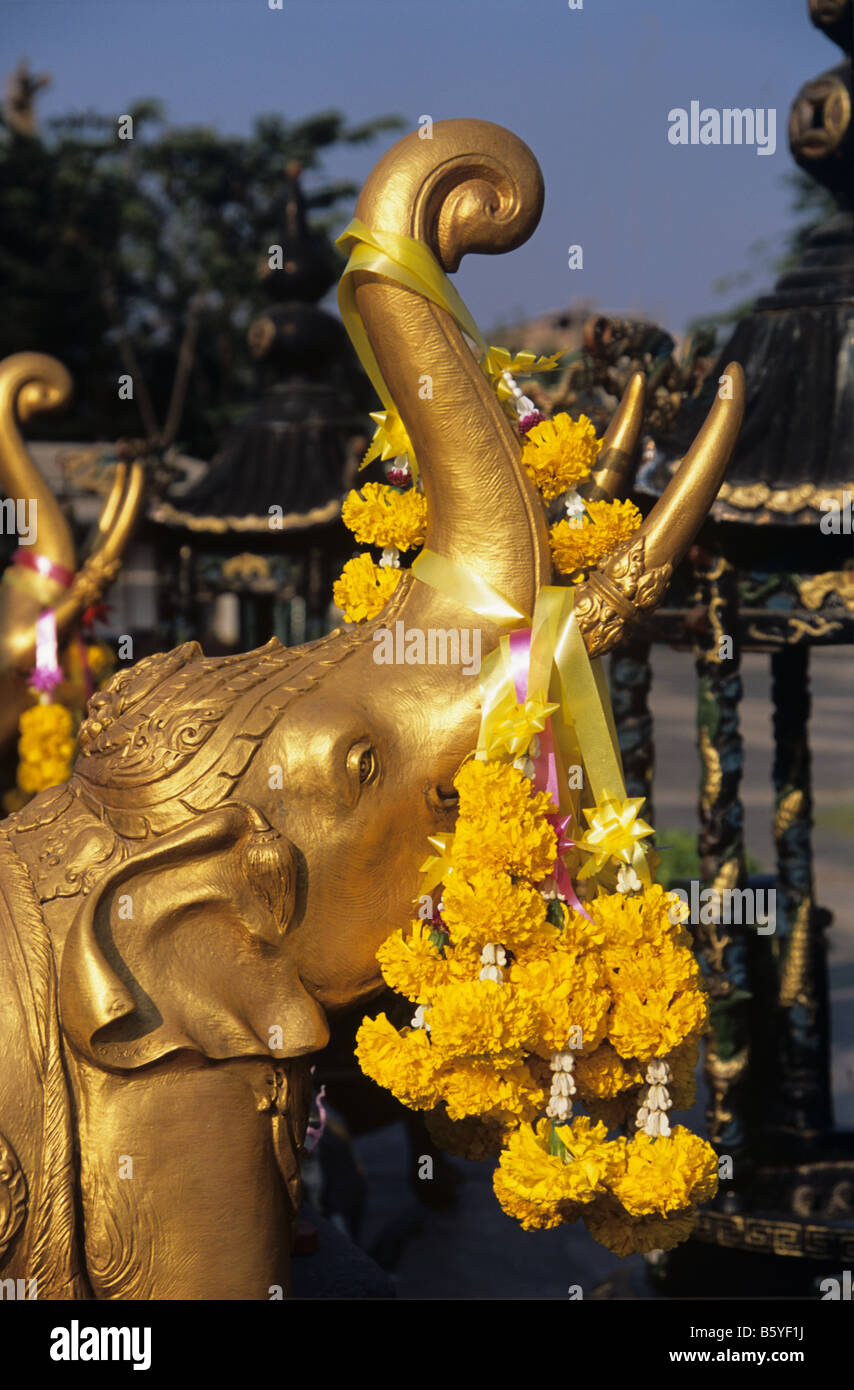 Blumengirlanden drapiert auf einer goldenen Elefanten an der 3-köpfigen Elefanten-Schrein, Teil des Erewan Museums, Bangkok, Thailand Stockfoto