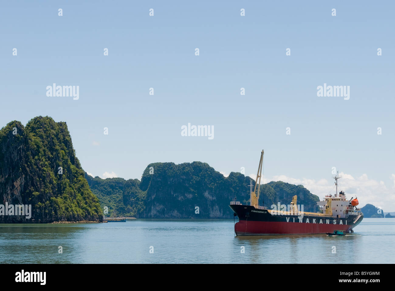 Ein Frachtschiff vor einem malerischen Hintergrund in der Ha Long Bucht, Vietnam Stockfoto