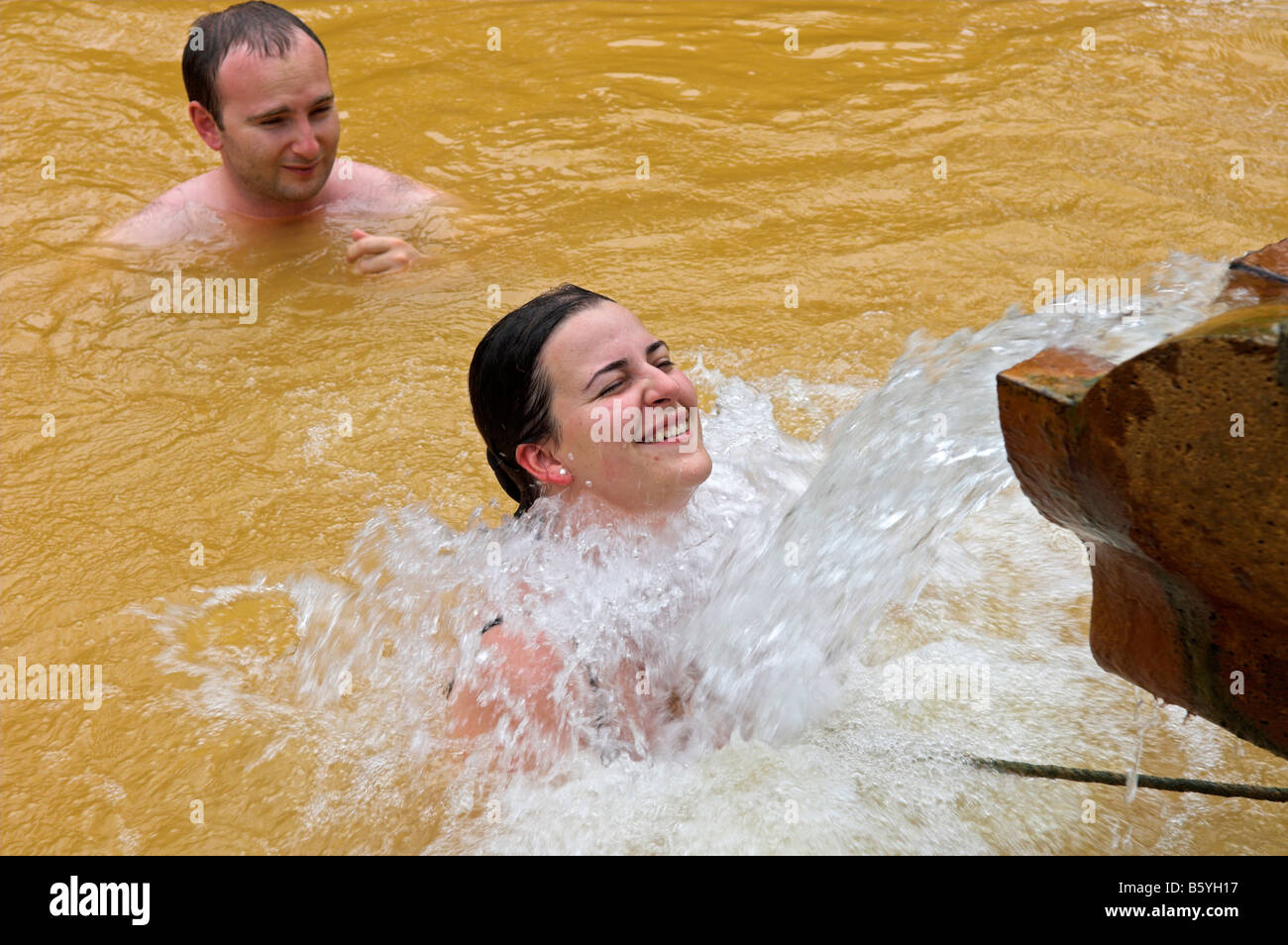 Frau unter Auslauf des thermischen heißen Mineralquelle bei Terra Nostra botanischen Garten Furnas Sao Miguel Azoren-Portugal Stockfoto