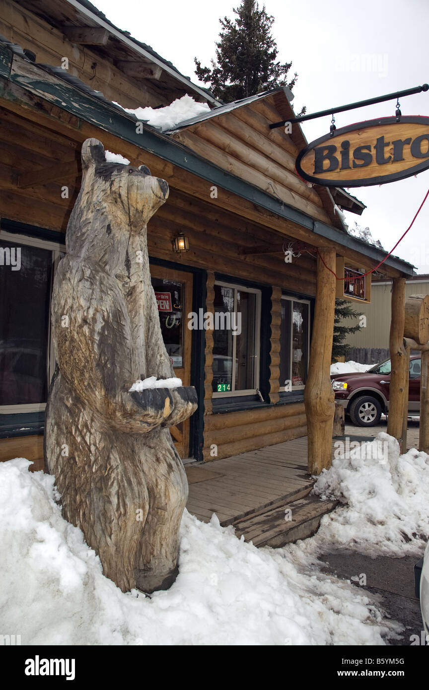 In Cooke City, Montana, wo live Bären häufig gesehen werden, steht ein hölzerner Bär außerhalb einer Stadt Café-bistro Stockfoto