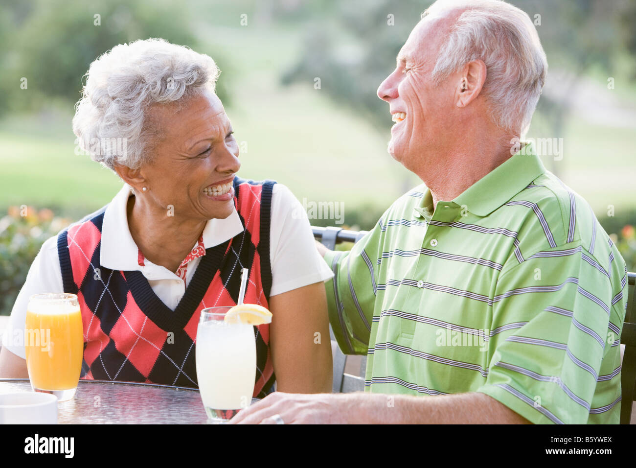 Paar genießt ein Getränk von einem Golfplatz Stockfoto