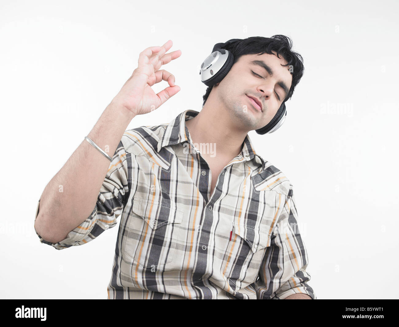 einen schönen asiatischen Mann indischer Herkunft, die Musik hören Stockfoto