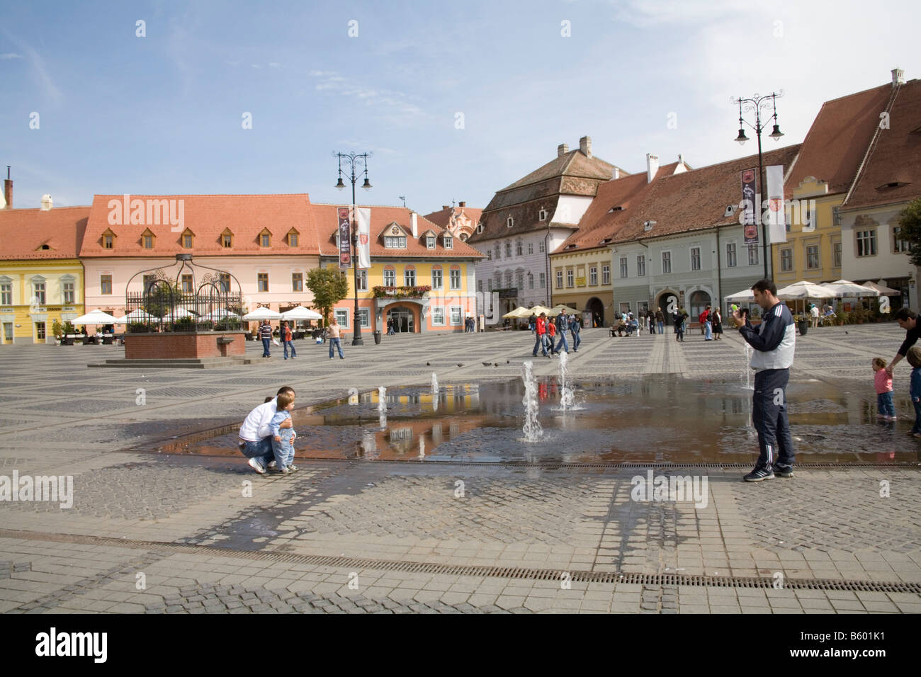 Sibiu Hermannstadt Siebenbürgen Rumänien Europa September Mann nehmen Foto von Frau und Kind durch Wasser Brunnen Piata Mare Stockfoto