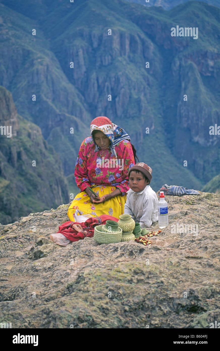 Ein Tarahumara indische Frau und ihr Sohn flechten Körbe aus Tannennadeln am Rande des Copper Canyon Mexiko Stockfoto