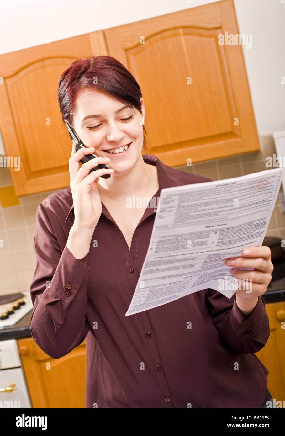 Junge Frau, die Zahlung einer Rechnung mit ihrem Handy und lächelnde Herr PR Stockfoto