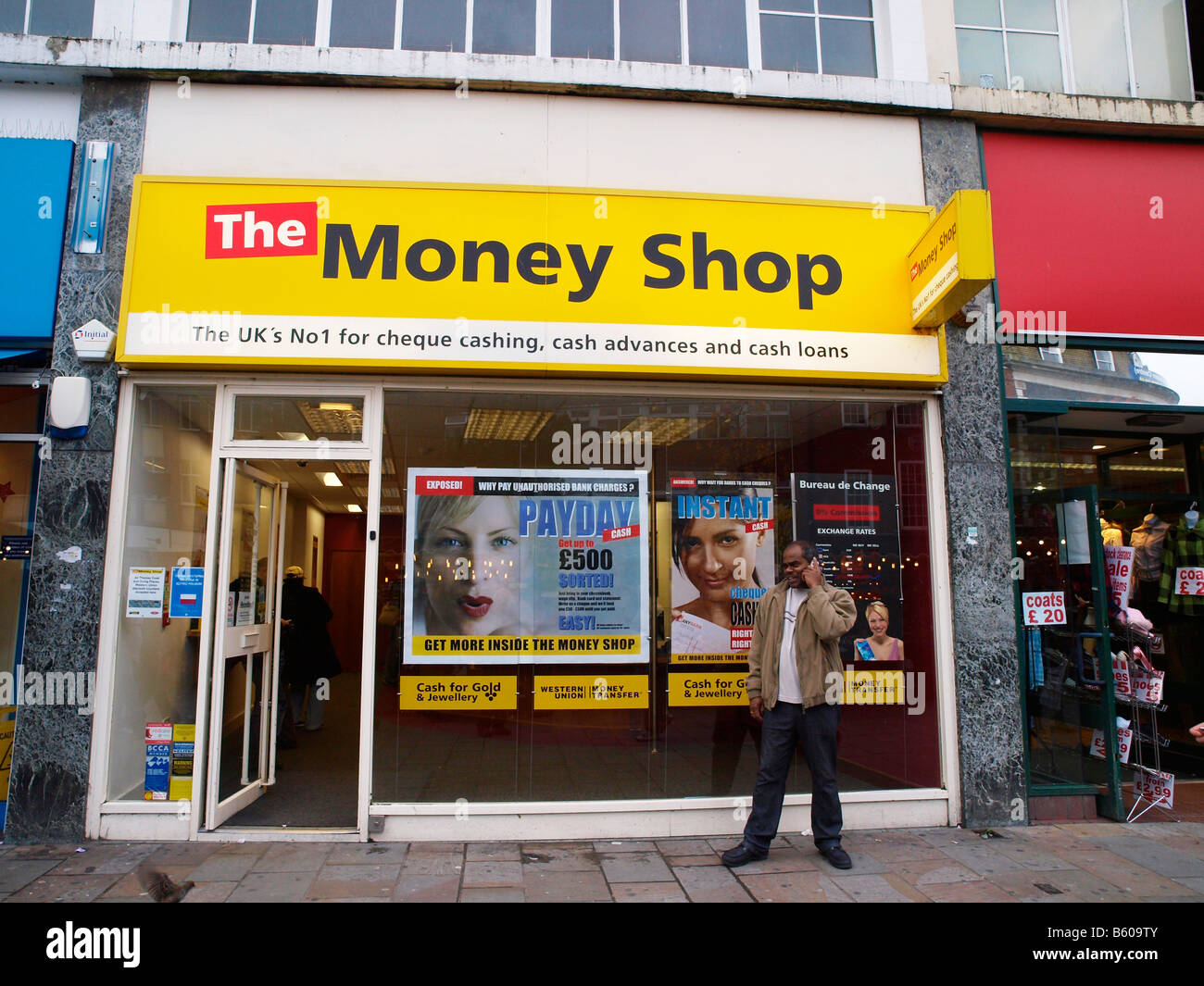 Mann auf einem Mobiltelefon außerhalb The Money Shop in Lewisham High Street London England. Stockfoto