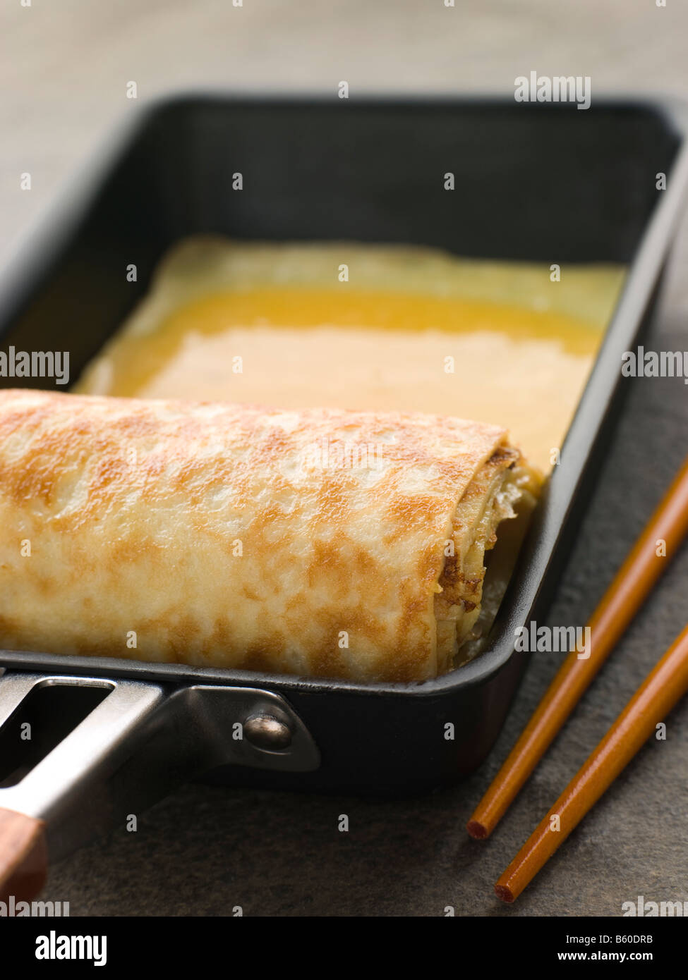 Gerollte Dashi Omelett in einer quadratischen Pfanne Stockfoto