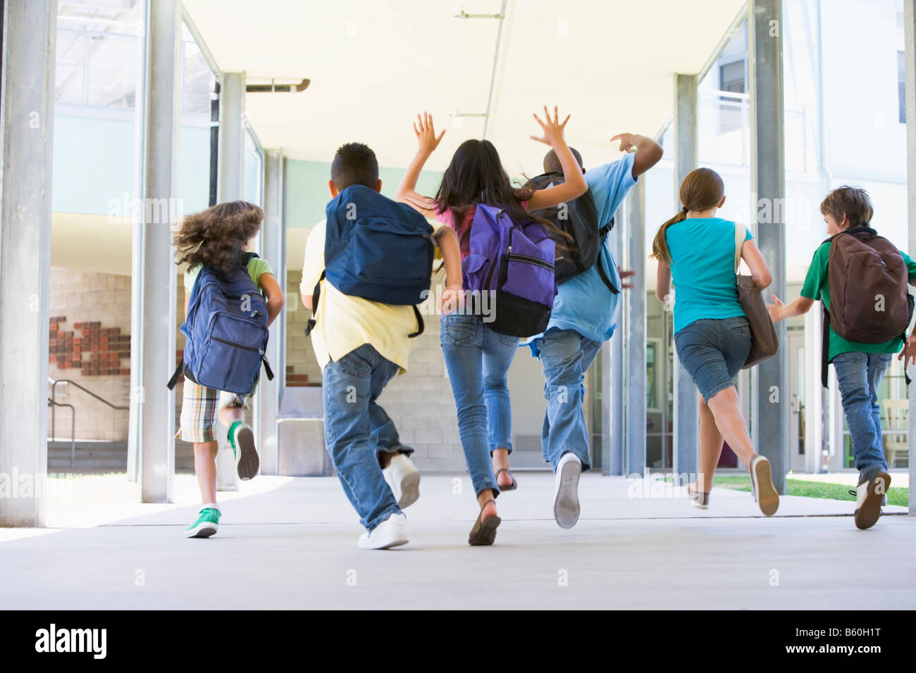 Sechs Studenten laufen bis vor die Haustür der Schule begeistert Stockfoto