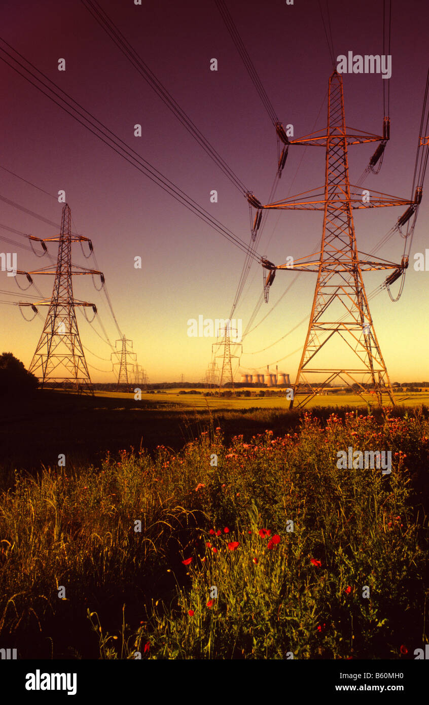 riesigen Strommasten führt durch die Landschaft in Ferrybridge Kohle betriebene Kraftwerk bei Sonnenaufgang Yorkshire UK Stockfoto