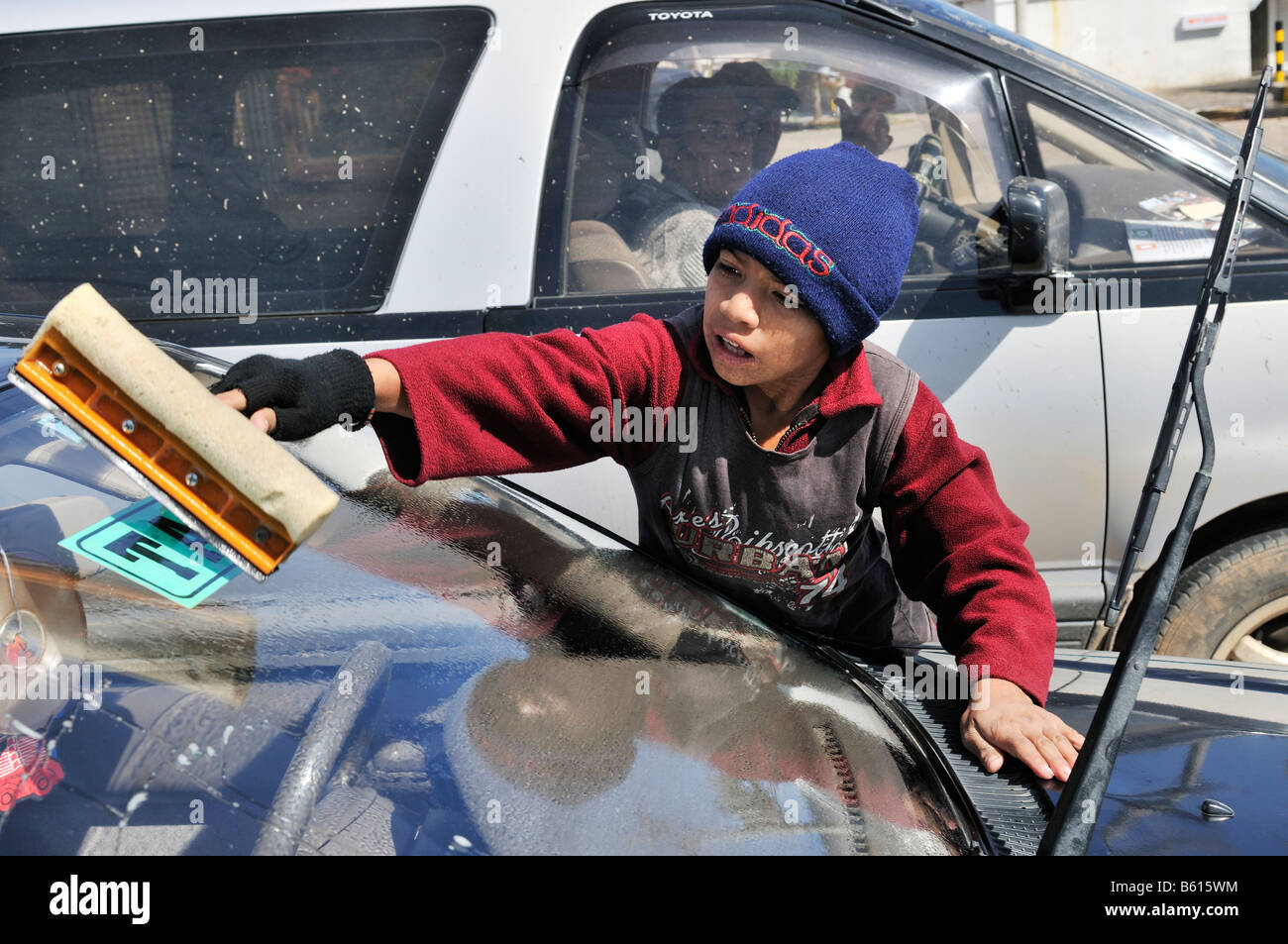 Kind Arbeit, zehn Jahre alte junge Reinigung Autoscheiben an eine Kreuzung, Santa Cruz, Bolivien, Südamerika Stockfoto