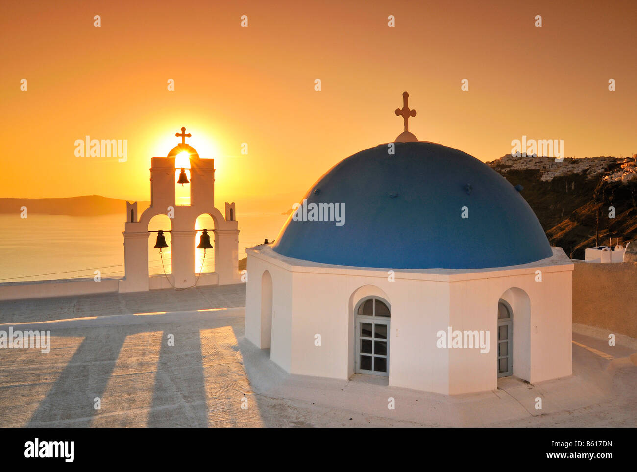 Weiße griechische Kirche mit einer blauen Kuppel und Glockenturm bei Sonnenuntergang, Firostefani, Santorin, Kykladen, Griechenland, Europa Stockfoto