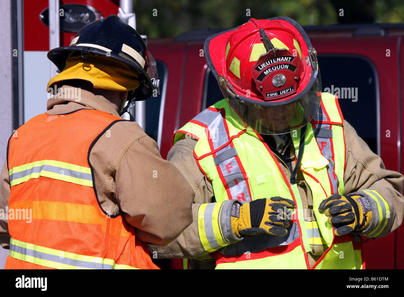 Ein Mequon Feuerwehr Leutnant und Feuerwehrmann setzen ihre Autobahn Sicherheitswesten, bei einem Verkehrsunfall zu verwenden Stockfoto