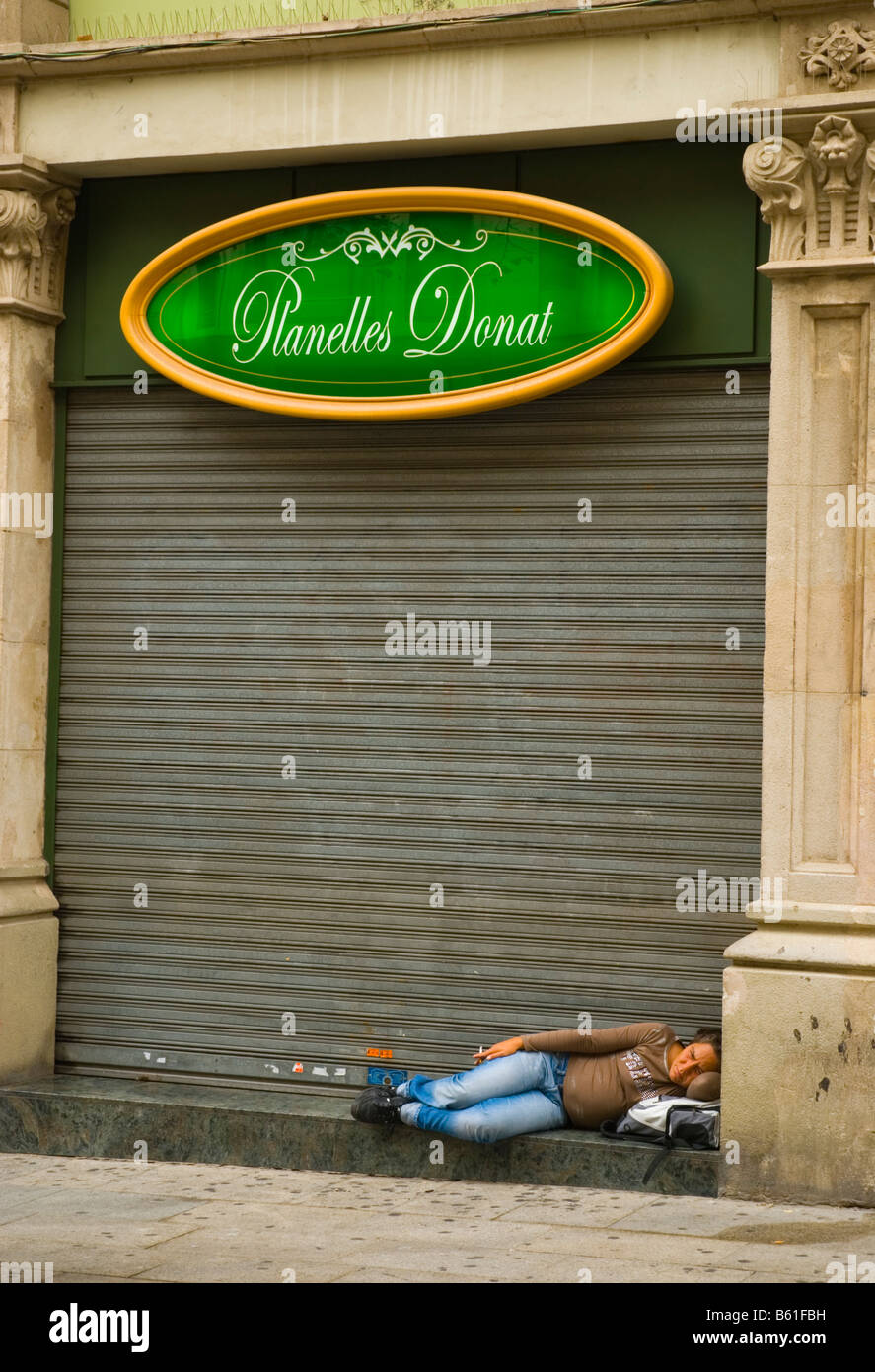 Person an der Tür ein Closed Shop entlang der Avinguda Portal de L Angel in Barcelona Spanien ruht Stockfoto