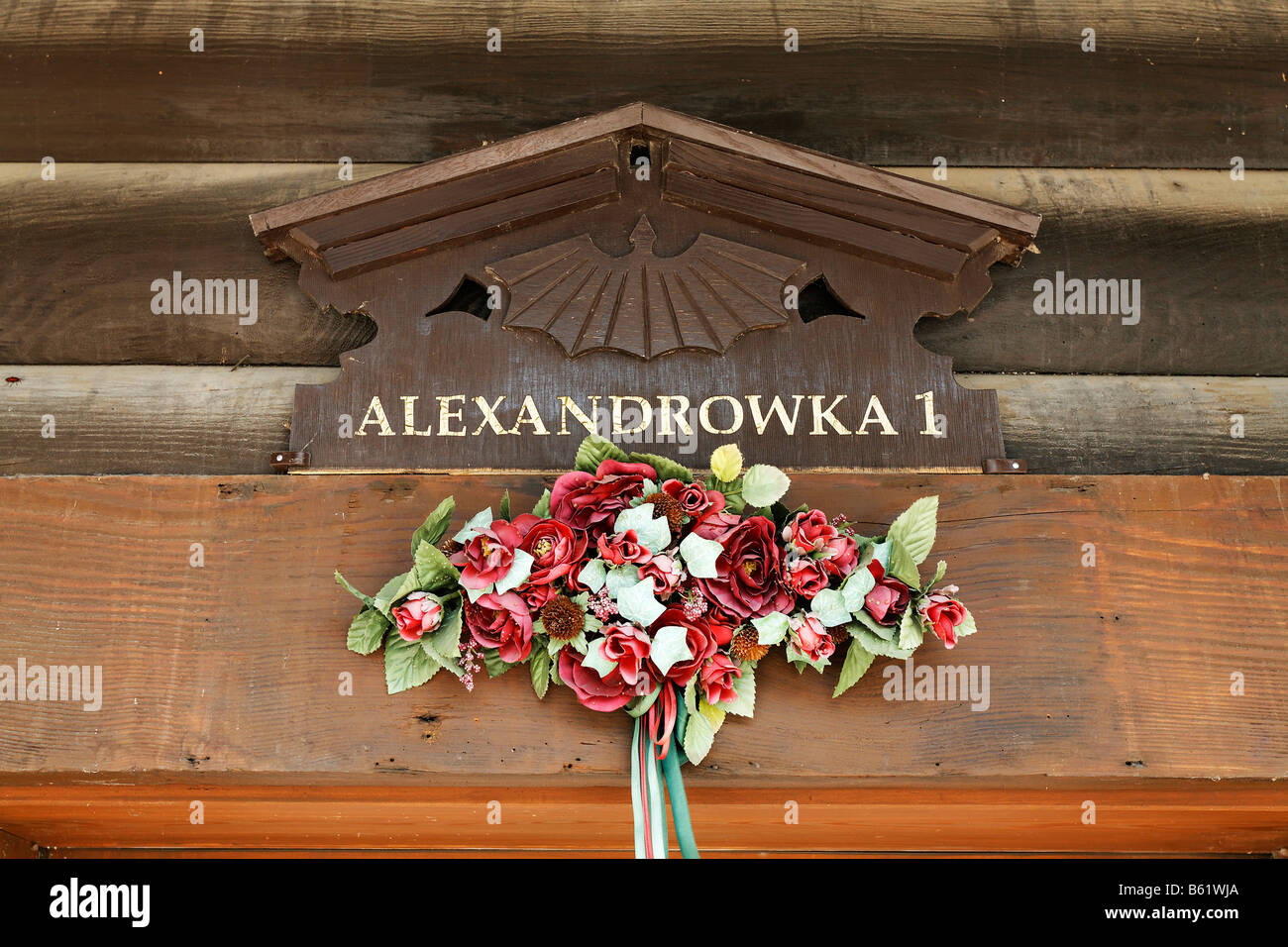 Geschnitzte Haus unterzeichnen Alexandrowka 1, dekoriert mit Kunstblumen, Detail, Russische Kolonie Alexandrowka, Potsdam, Brandenburg, Keim Stockfoto