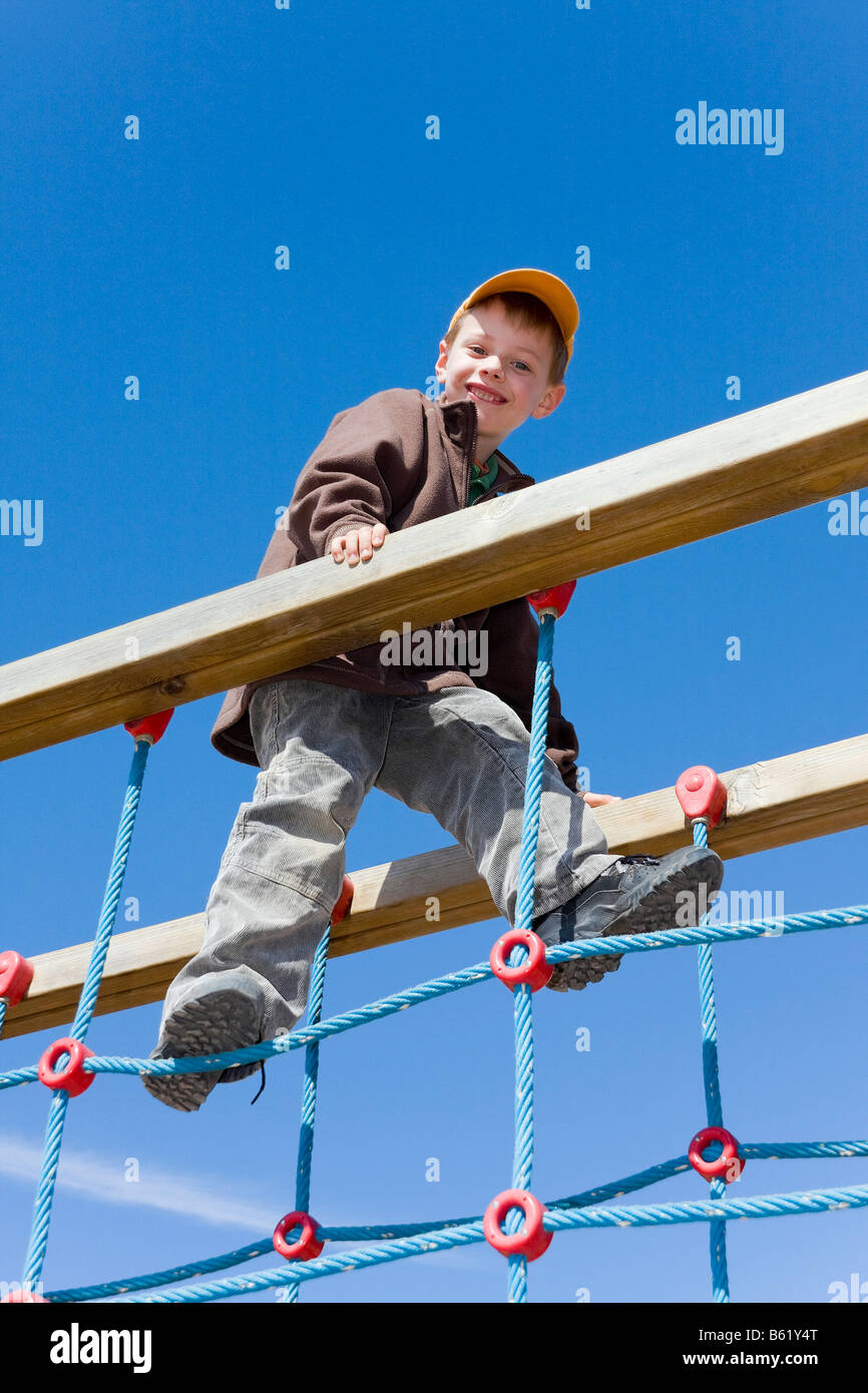 Junge, Klettern 6 Jahre alt, auf einem Spielplatz Stockfoto
