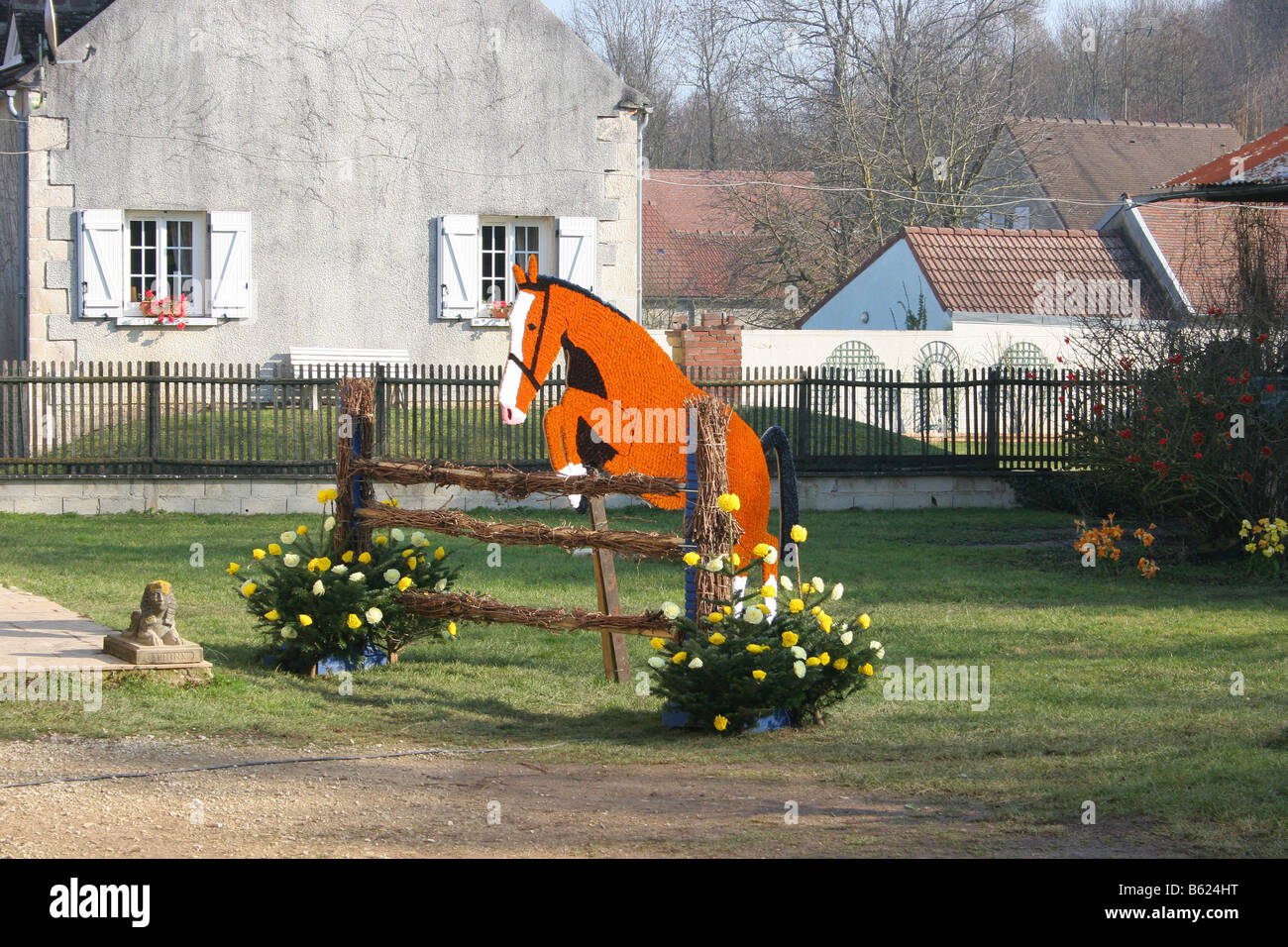 Pferd springen Zaun aus Papierblumen, St Vincent Festival, Villy in der Nähe von Chablis, Burgund, France.Horizontal 50560 Chablis2005 Stockfoto