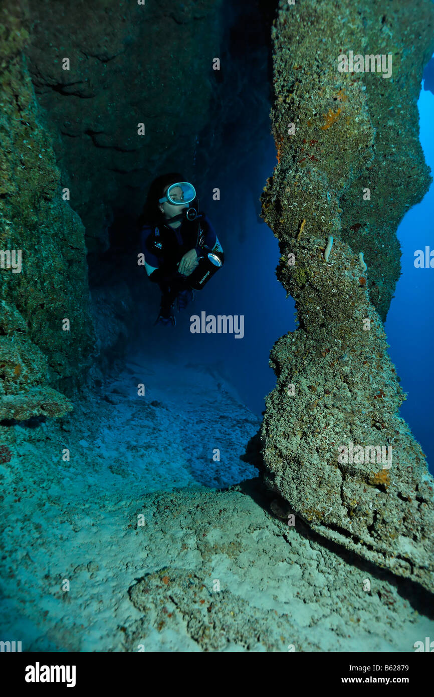 Weibliche Taucher mit einer Lampe, Blick auf Stalctites und Stalagmiten, die sich in einer Tiefe von 45 m in das Blue Hole Nati zusammengeschlossen haben Stockfoto
