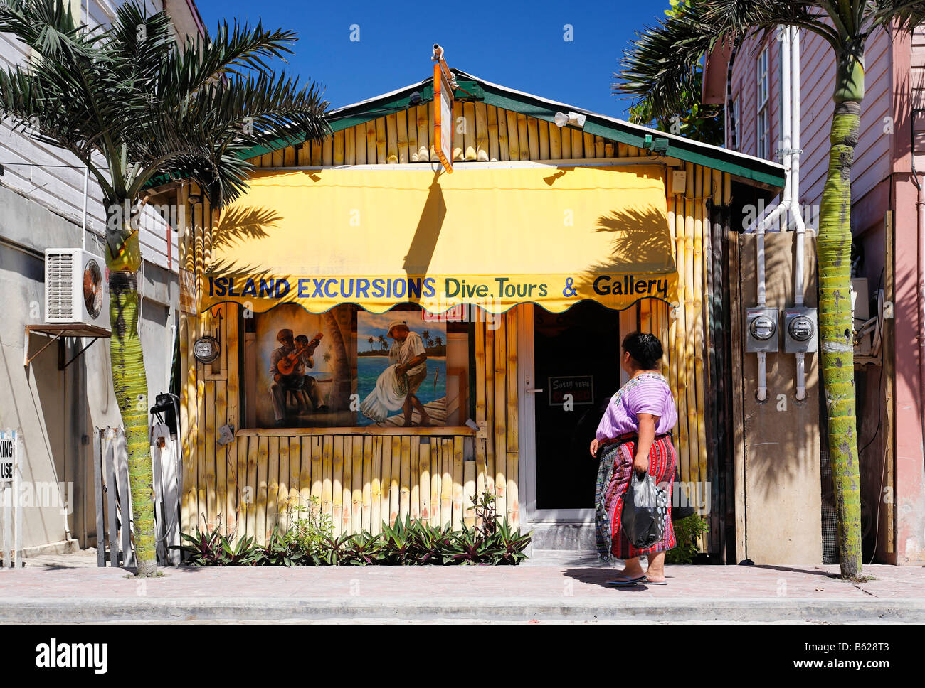 Geschäft machte Bambus zwischen zwei Palmen, Fußgänger Frau in San Pedro, Ambergris Cay Insel, Belize, Mittelamerika, Cari Stockfoto