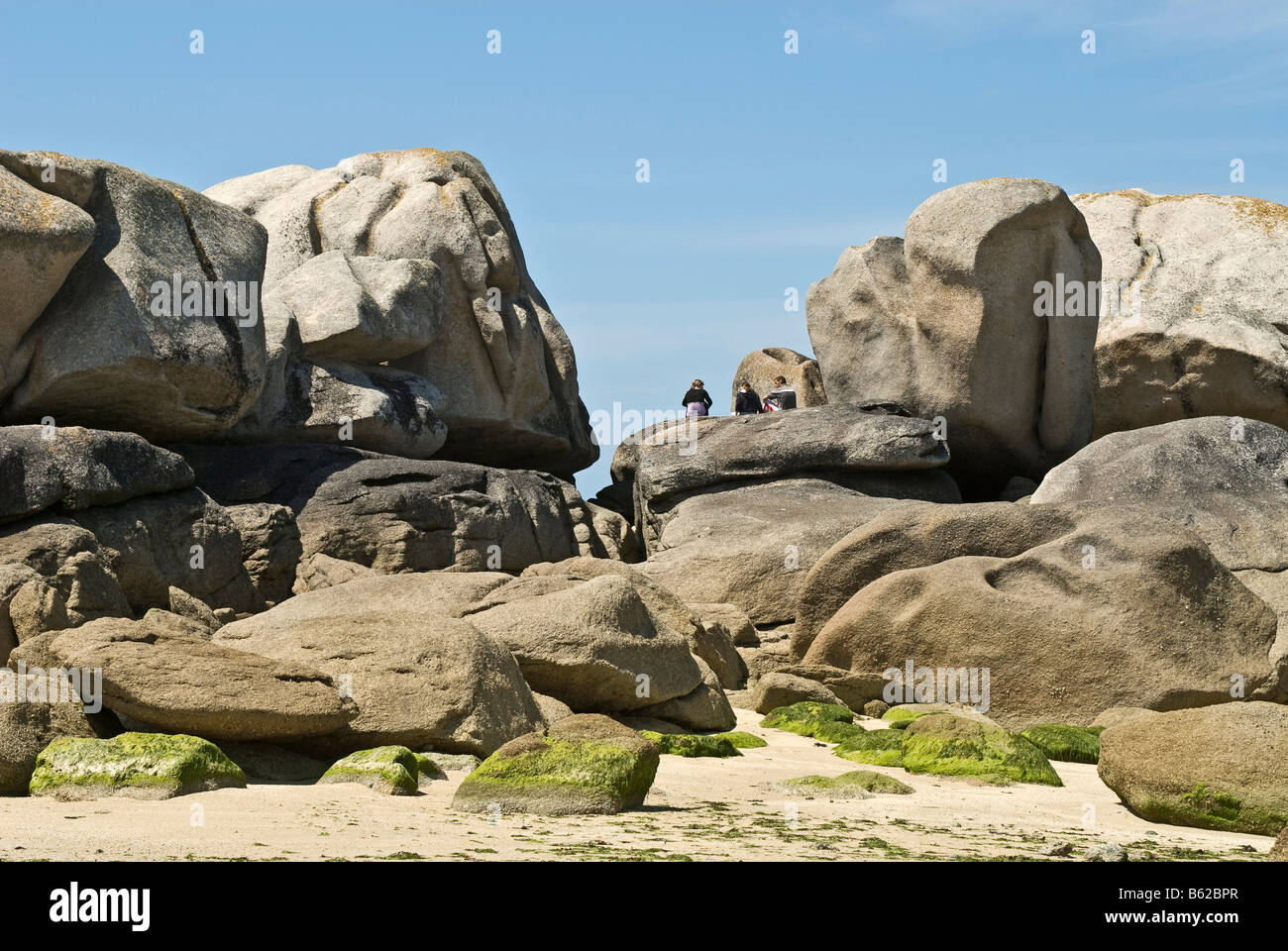 Menschen im Urlaub sitzt auf einer Felsformation in der Nähe der Phare de Pontusval, Brignogan, Bretagne, Frankreich, Europa Stockfoto