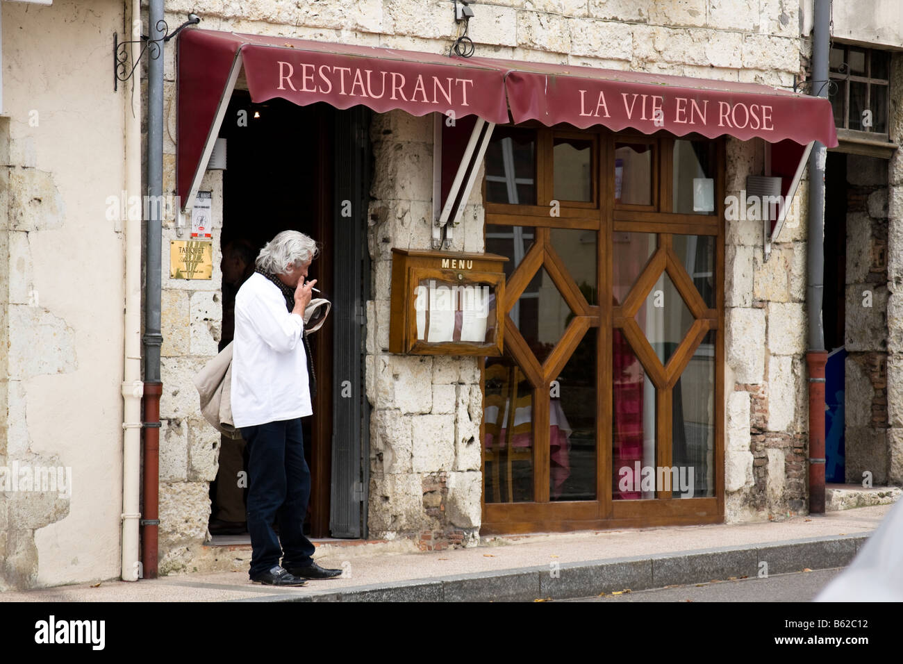 Mann Rauchen außerhalb Restaurants, Bergerac - Gers, Südfrankreich Stockfoto