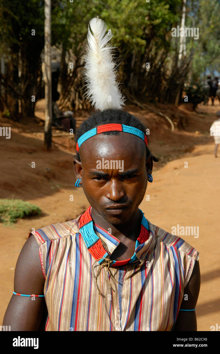 Portraitof ein junger Mann trug eine bunte Halskette und eine weiße Feder in seine Haare, Äthiopien, Afrika Stockfoto