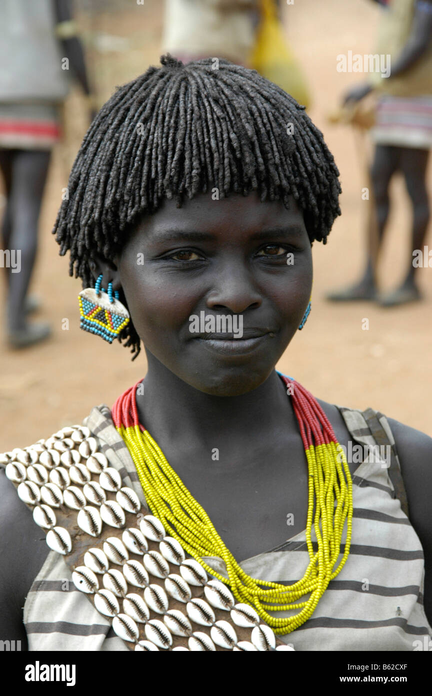 Porträt einer lächelnden jungen Frau mit einem bunten Halskette und Kauri Muscheln, Keyafer, Äthiopien, Afrika Stockfoto