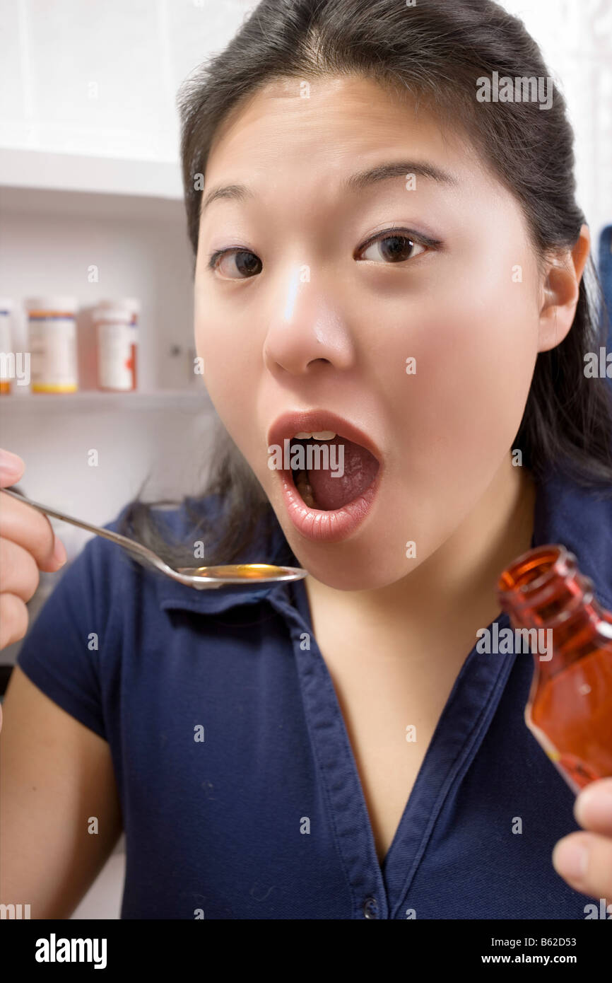 Frau zu Hause Einnahme von flüssigen Arzneimitteln Stockfoto