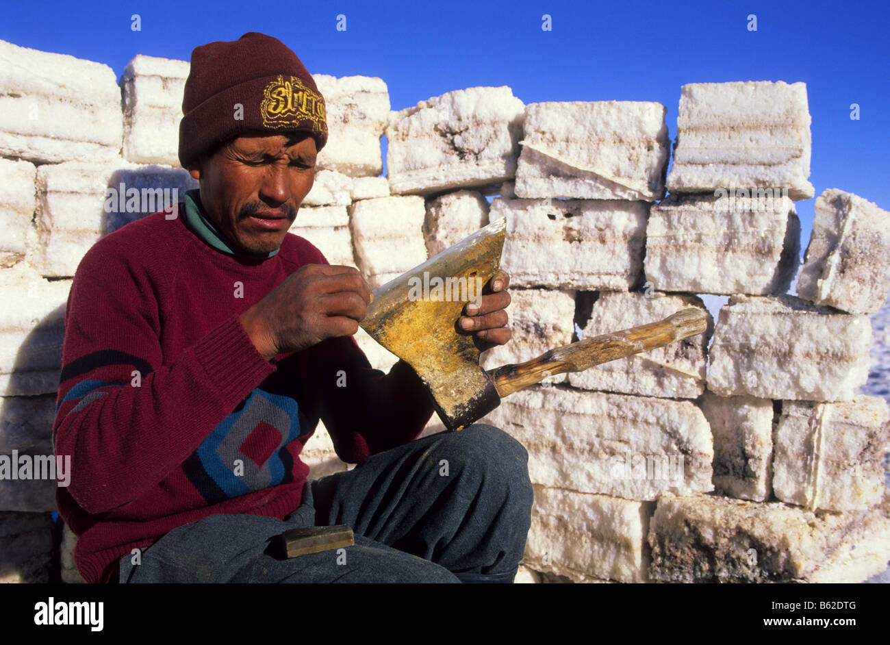 Inocencio Flores schärft es eine Axt in einen Mantel von Blöcken Salz gebaut. Salar de Uyuni. Bolivien. Stockfoto