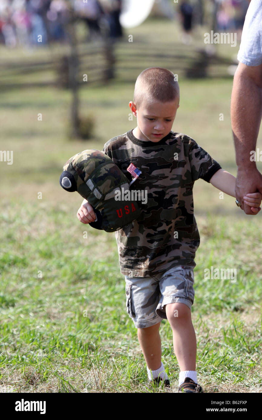Ein kleiner Junge und sein Vater Hand in Hand am Bürgerkrieg Schlacht Reenactment hält eine gefüllte militärische Auto Stockfoto