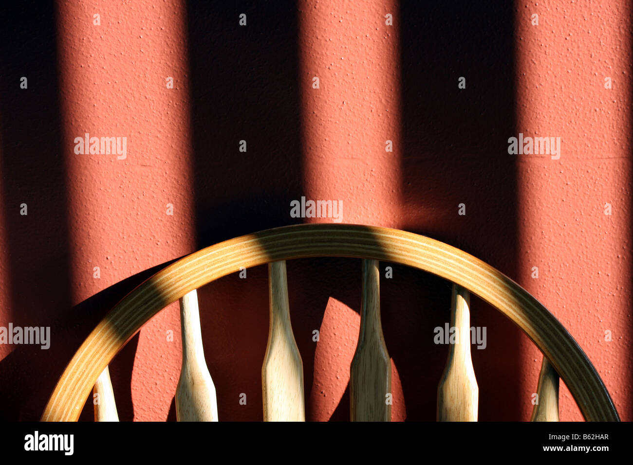 Ein Stuhl und Schatten auf einer bemalten Wand Stockfoto