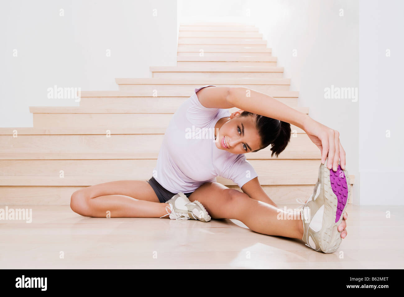 Junge Frau, die Ausübung auf dem Boden Stockfoto