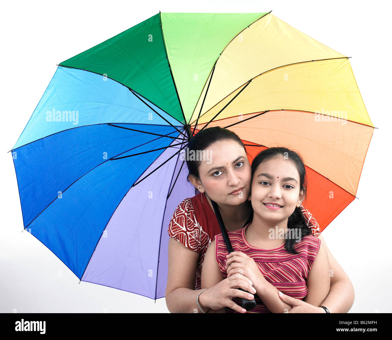 Mutter und Tochter mit einem mit Regenbogen Regenschirm Stockfoto