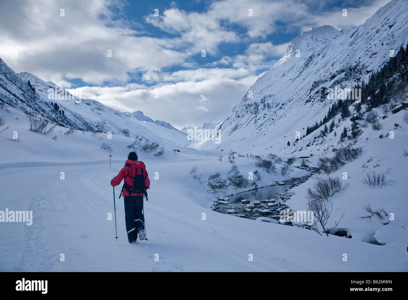 Winter Wanderer neben einem Gebirgsbach, Ischgl, Tirol, Österreich. Stockfoto