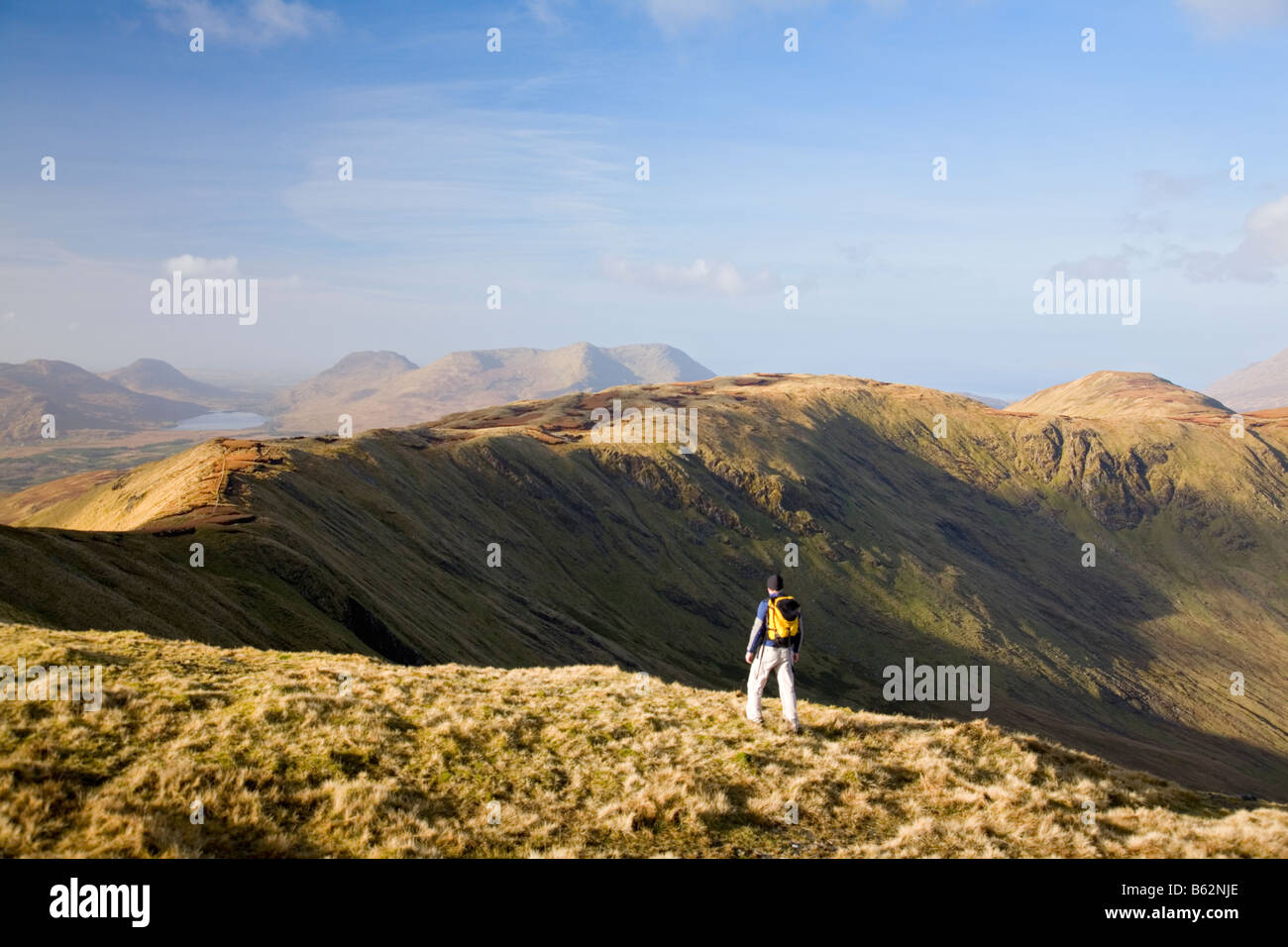 Wanderer mit Blick über die Berge von Connemara Leenaun Hill, Connemara, County Galway, Irland. Stockfoto