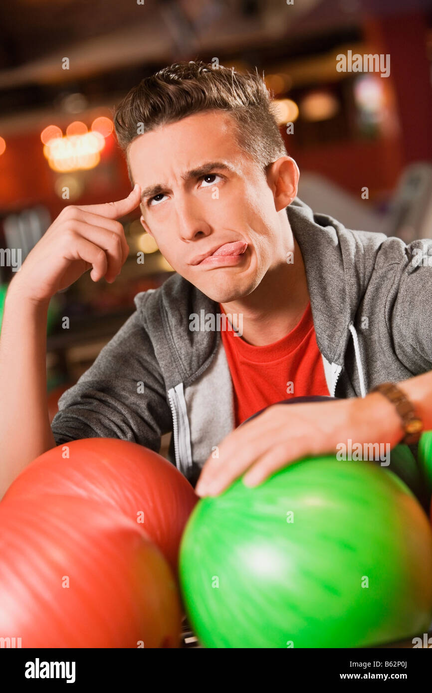 Nahaufnahme eines jungen Mannes, seine Zunge heraus und denken Stockfoto