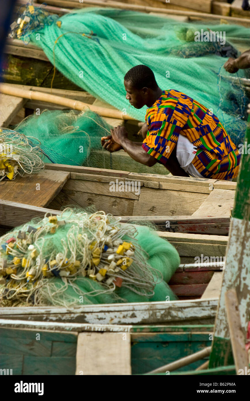 Ein Fischer neigt dazu, seine Netze in Cape Coast, Ghana nach einem Tag der Fischerei Stockfoto