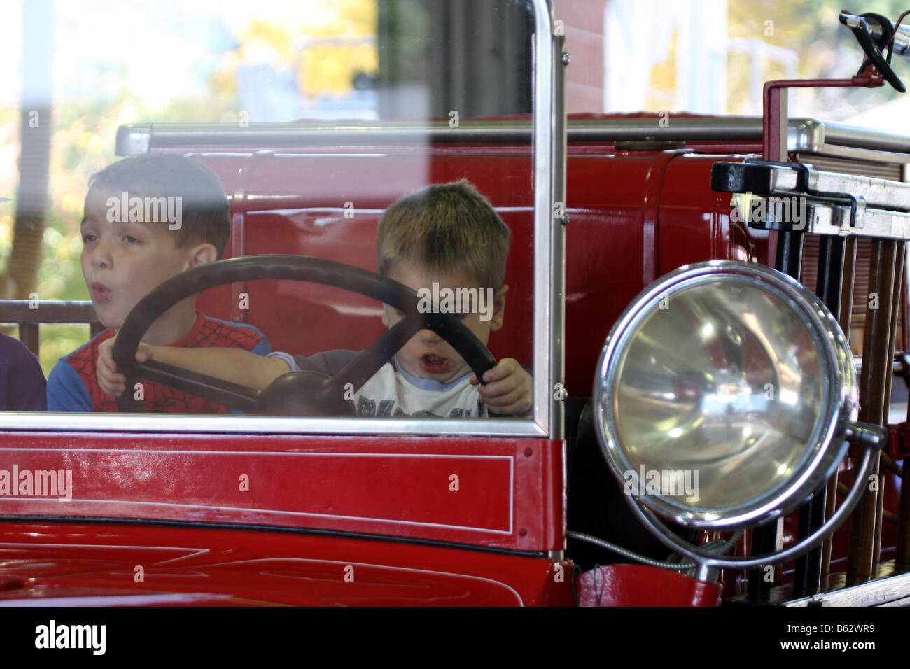 Kinder genießen so tun, als Antriebsmotor ein 1933 Pirsch Sterling Feuer an einem Feuer Sicherheit faire Stadt Mequon Wisconsin Stockfoto