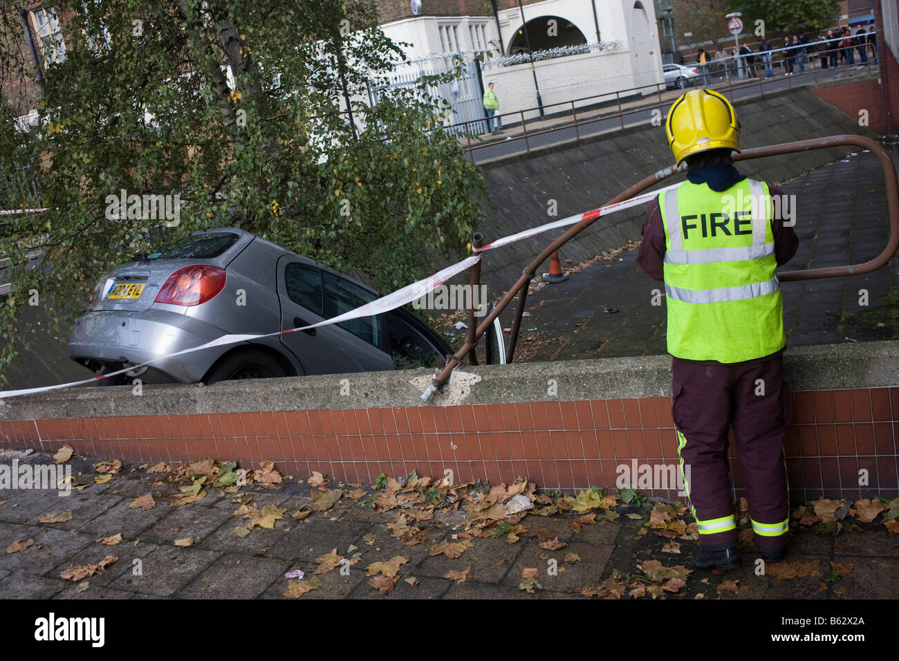 Die Londoner Feuerwehr kümmern sich um das Wrack eines Kleinwagens, die über eine Bürgersteigkante Elefant & Schloss getrieben hat Stockfoto