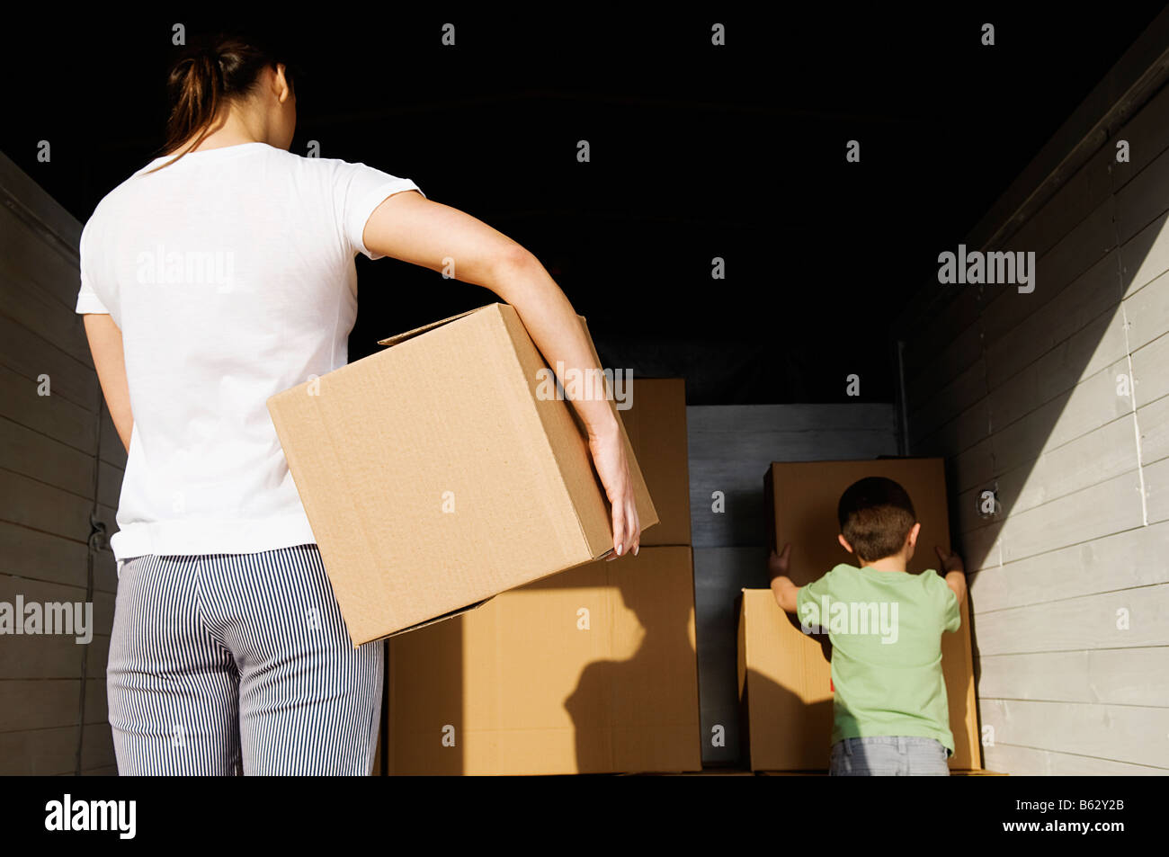 Rückansicht einer jungen Frau mit einem Karton Stockfoto