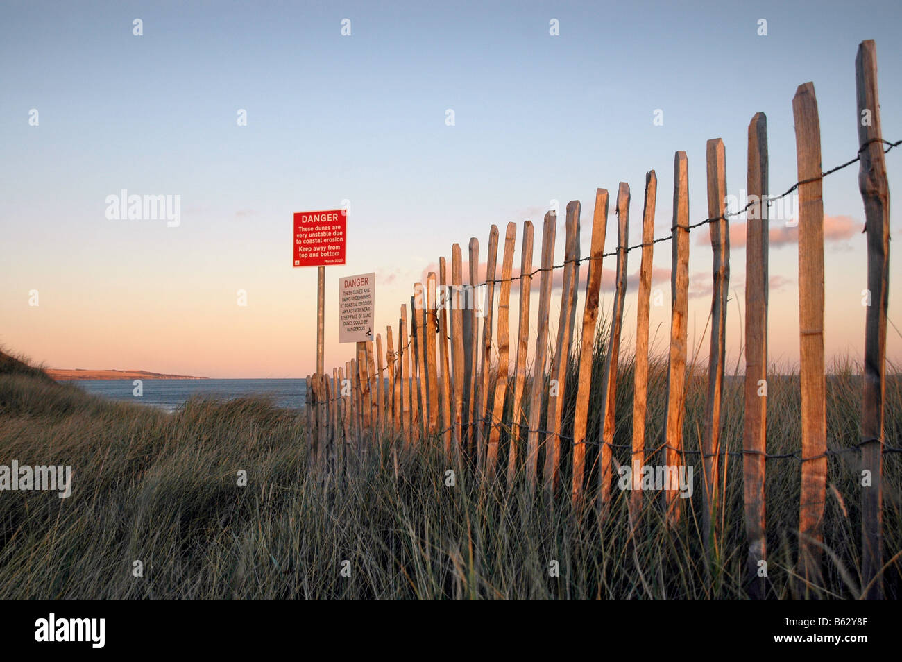 Zaun und Schilder Warnung vor der Gefahr der Aushöhlung Sanddünen am Strand von Montrose. Stockfoto