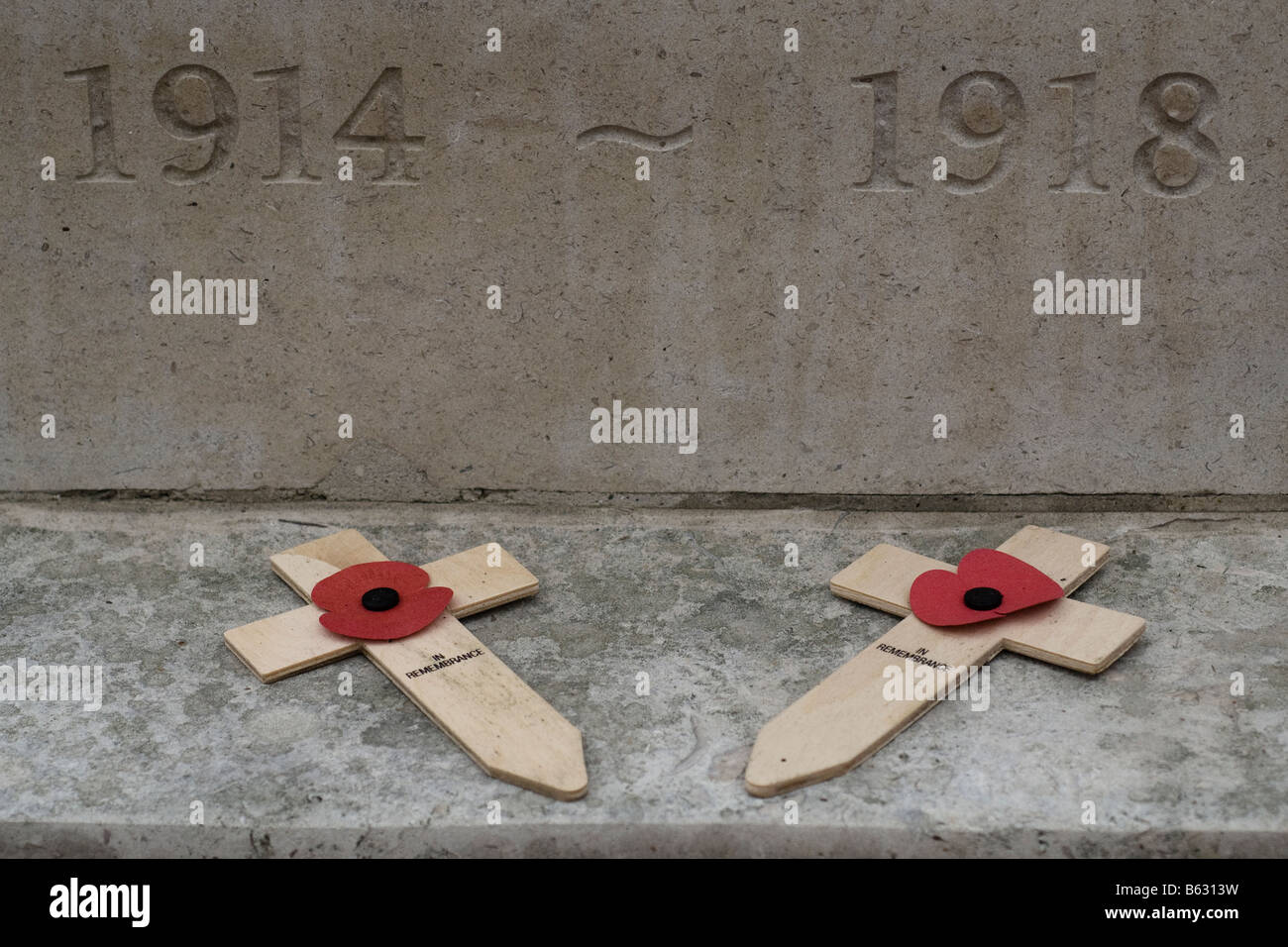 Holzkreuze mit Mohnblumen unterhalb 1914 1918 Carven auf einem Kriegerdenkmal für Gedenktag 11. November Stockfoto