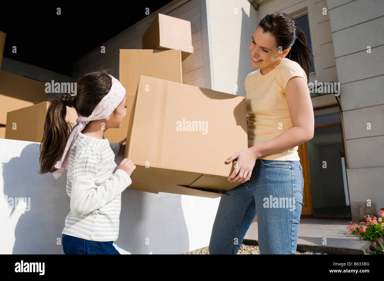 Seitenansicht von einer reifen Frau und ihre Tochter mit einem Karton Stockfoto