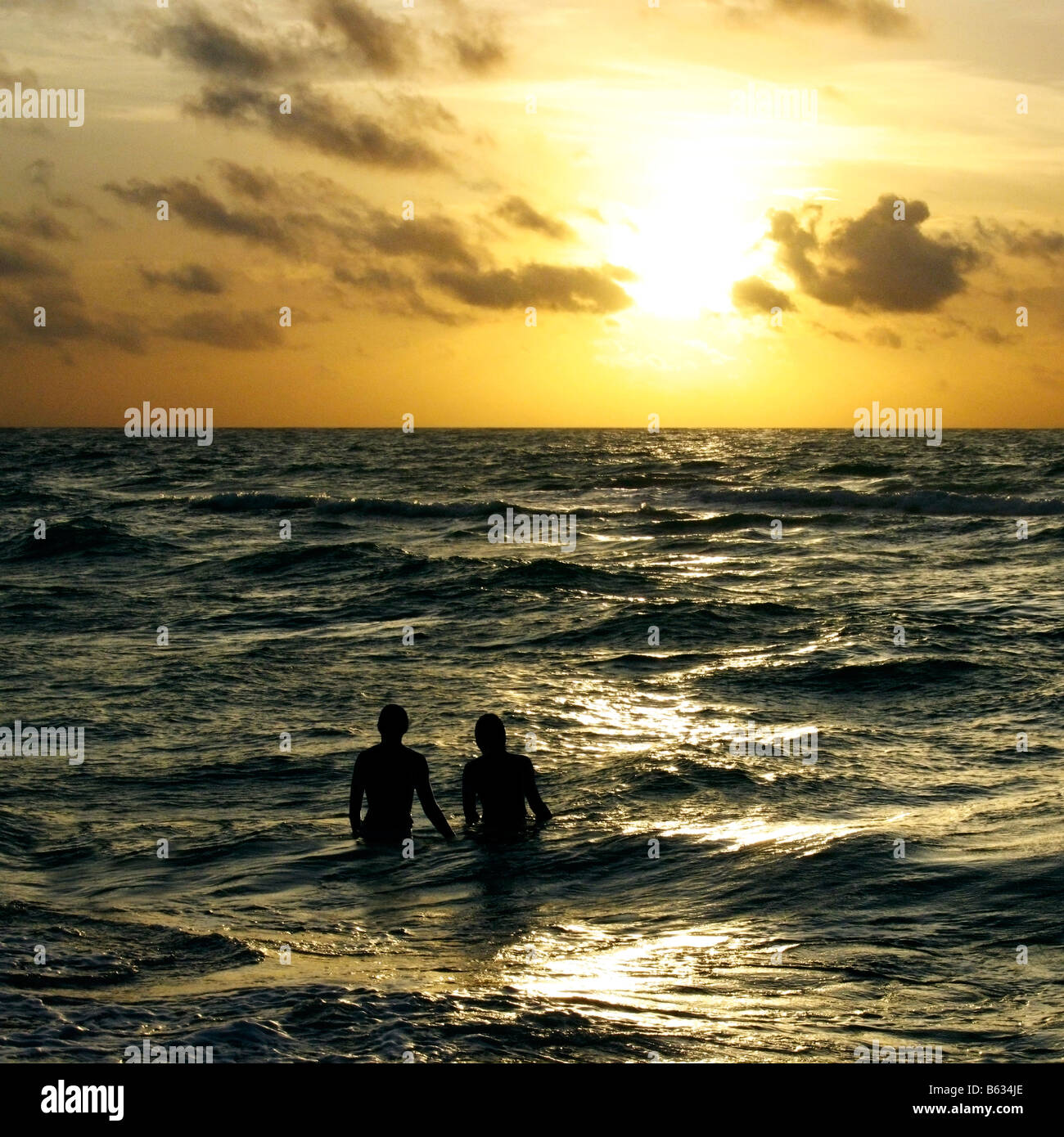 Silhouette von ein paar stehen im Meer in der Abenddämmerung Stockfoto