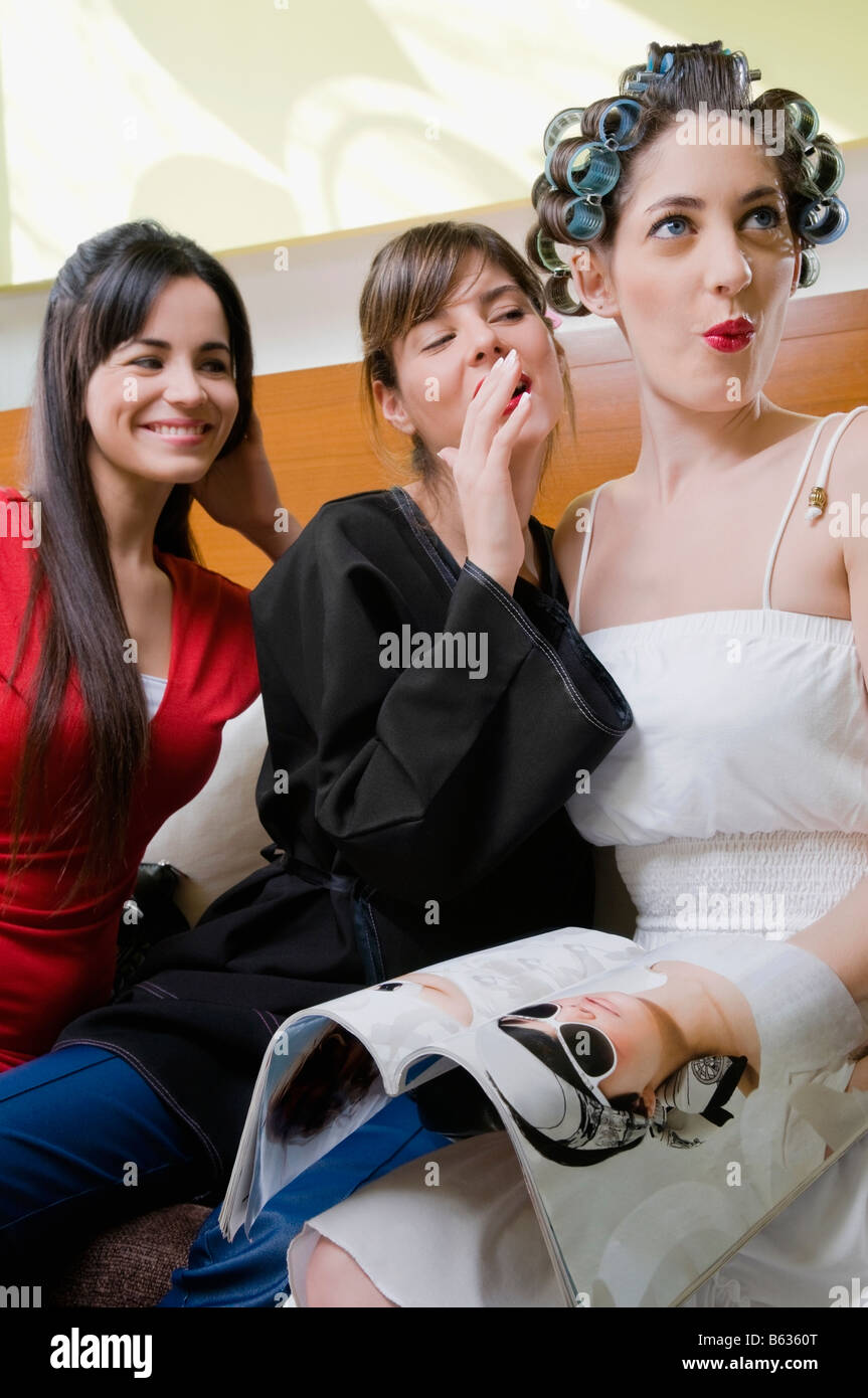 Drei Freunde auf einer Couch sitzen und Lächeln Stockfoto