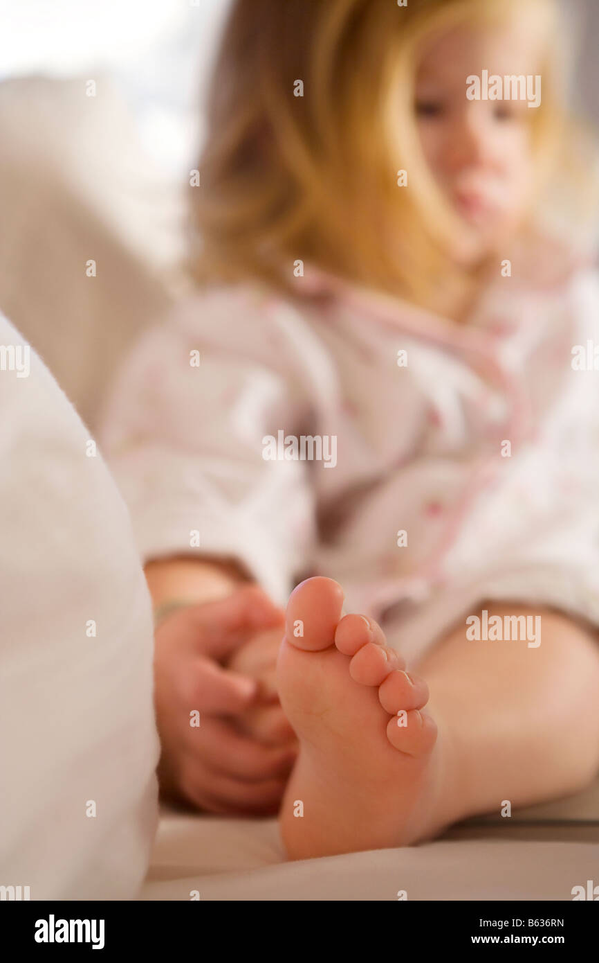 Nahaufnahme von einem Babymädchen sitzt auf dem Bett Stockfoto