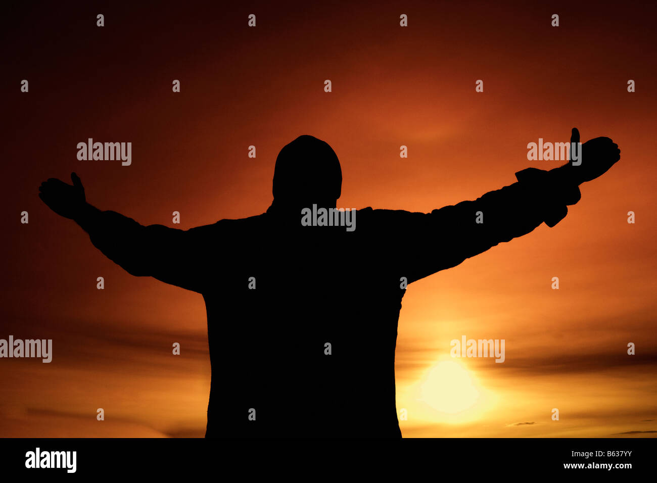 Silhouette einer Person mit erhobenen Armen stehend Stockfoto