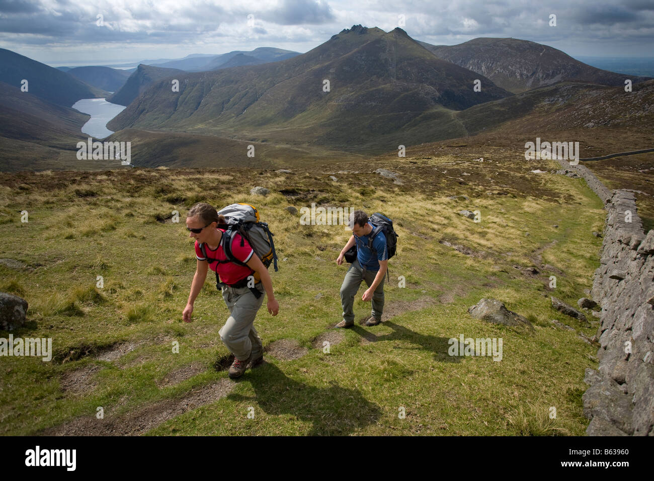 Wanderer über dem stillen Tal in der Nähe der Gipfel des Slievenaglogh, Mourne Mountains, County Down, Nordirland, Großbritannien. Stockfoto