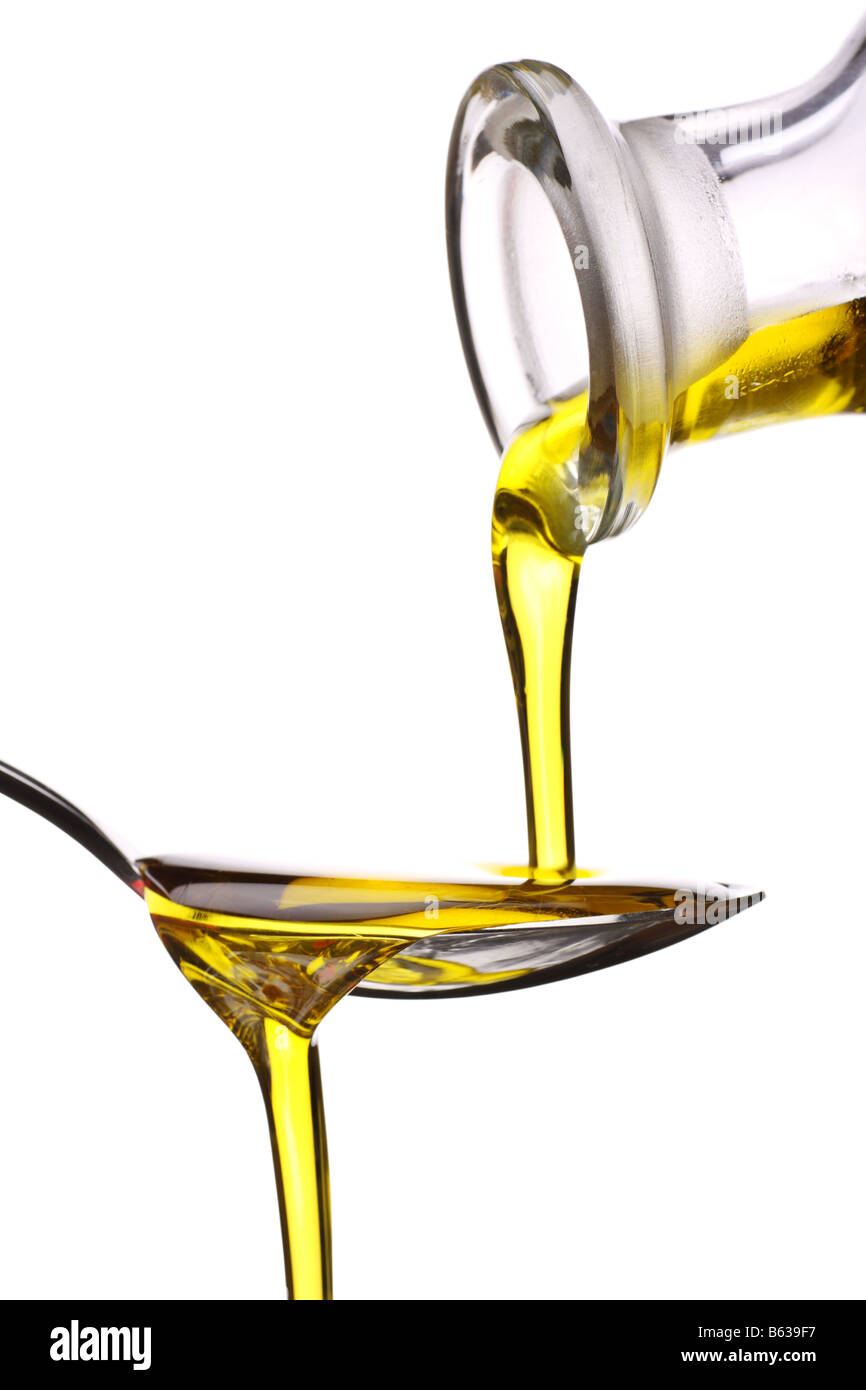 Natives Olivenöl extra wird auf einem Löffel gegossen Stockfoto